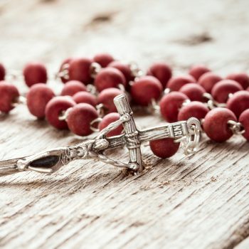 Close-up of  rosary on old wooden texture background